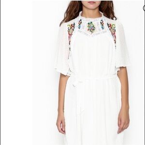 White floral embroidered dress,has a dotted texture, with a flower embroidered.